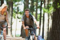 Sorridente coppia mountain bike nel bosco — Foto stock