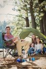 Familia sonriente en el camping en los bosques - foto de stock