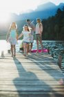Family walking on dock over lake — Stock Photo