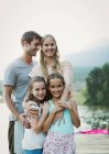 Famiglia sorridente sul molo sul lago — Foto stock