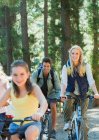Усміхнена сімейна їзда на велосипеді в лісі — стокове фото