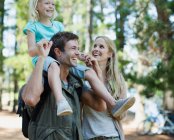 Father carrying daughter on shoulders in woods — Stock Photo