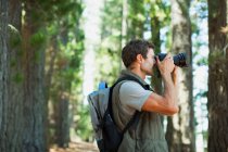 Людина використовує цифрову камеру в лісі — стокове фото