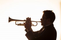 Silhouette de trompettiste performant — Photo de stock