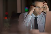 Focused businessman working late at laptop — Stock Photo