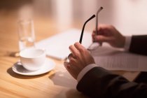 Geschäftsmann hält Brille über Papierkram — Stockfoto