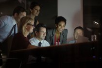 Деловые люди, работающие за ноутбуком в конференц-зале ночью — стоковое фото