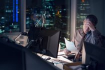 Напружений бізнесмен працює пізно в офісі — стокове фото