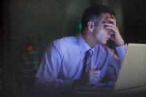 Tired businessman working late at laptop — Stock Photo