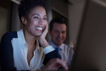Усміхнені бізнесмени працюють на ноутбуці — стокове фото