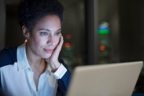 Femme d'affaires concentrée travaillant tard à l'ordinateur portable — Photo de stock