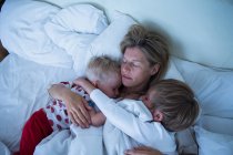 Mãe com filhos dormindo na cama — Fotografia de Stock