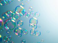 Burbujas translúcidas sobre fondo azul - foto de stock