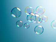 Burbujas translúcidas sobre fondo azul - foto de stock