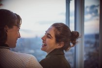 Lachende Geschäftsfrauen am Bürofenster — Stockfoto