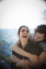 Щаслива молода пара сміється і обіймається на балконі — стокове фото