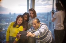 Empresários tirando selfie na janela do escritório highrise — Fotografia de Stock