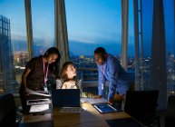 Geschäftsleute arbeiten spät am Laptop im Konferenzraum des Hochhauses — Stockfoto