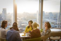 Business people talking in sunny highrise office cafeteria — Stock Photo