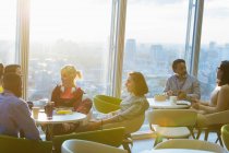Business people meeting in sunny highrise office cafeteria — Stock Photo
