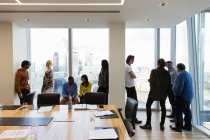 Business people talking at highrise conference room windows — Stock Photo