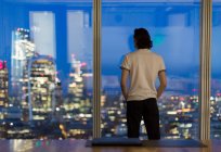 Nachdenklicher Geschäftsmann arbeitet spät am Hochhausfenster, London, Großbritannien — Stockfoto