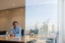 Thoughtful businessman in highrise conference room, London, UK — Stock Photo