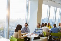 Business people meeting in sunny highrise office cafeteria — Stock Photo