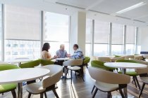Geschäftsleute treffen sich in sonniger Büro-Cafeteria — Stockfoto