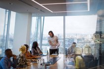 Businessman leading conference room meeting in highrise office — Stock Photo