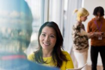 Mujer de negocios sonriente hablando con su colega en el cargo - foto de stock
