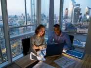 Бізнесмени, які працюють на ноутбуці у високогірному офісі, Лондон, Велика Британія. — стокове фото