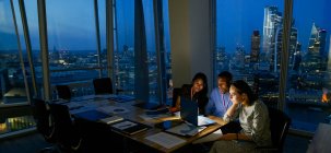 Geschäftsleute arbeiten spät am Laptop im Hochhaus-Büro, London, Großbritannien — Stockfoto