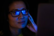 Cerca de reflexión portátil en gafas de mujer de negocios trabajando hasta tarde - foto de stock