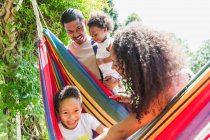 Porträt glückliche Familie in sonniger Sommerhängematte — Stockfoto