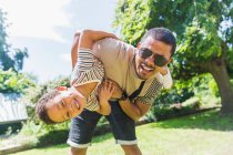 Portrait playful father and son in sunny backyard — Stock Photo