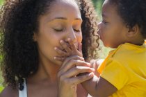 Close up affectionate mother kissing hand of toddler daughter — Stock Photo