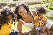 Portrait happy mother and children in sunny summer yard — Stock Photo