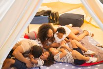Verspielte Familie kitzelt und lacht im Zelt — Stockfoto