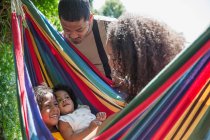 Eltern beobachten glückliche Töchter in sonniger Sommerhängematte — Stockfoto