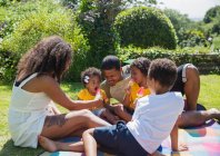Щаслива сім'я їсть паприки з кавуна на сонячному літньому подвір'ї — стокове фото