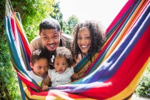 Retrato família feliz na rede de verão ensolarada — Fotografia de Stock