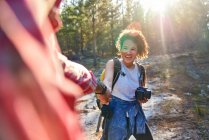 Glückliches junges Paar wandert mit Kamera im sonnigen Wald — Stockfoto