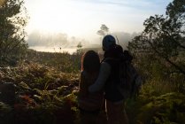 Silhouette young couple hiking and enjoying tranquil nature view — Stock Photo
