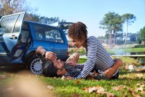 Affectionate young couple laying in sunny autumn grass — Stock Photo