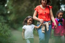 Mother and daughters hiking on trail in woods — Stock Photo