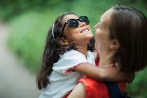 Щаслива мати тримає дочку в сонцезахисних окулярах — стокове фото