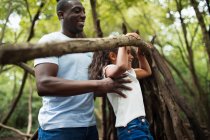 Father and daughter playing with branch in woods — Stock Photo