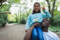 Porträt Vater trägt Tochter gestikulierend im Wald — Stockfoto
