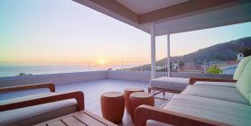 Escénica puesta de sol vista al mar desde el balcón de lujo casa escaparate - foto de stock